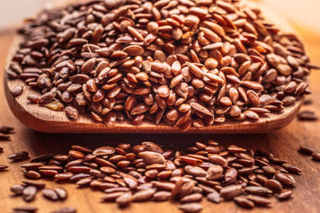 Healthy food for preventing heart diseases and overweight. Flax seeds linseed on wooden spoon wood backgroundの写真素材
