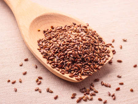 Healthy food for preventing heart diseases and overweight. Flax seeds linseed on wooden spoon burlap backgroundの写真素材