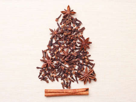 Christmas tree made from brown spices cinnamon stick anise stars and cloves on burlap backgroundの写真素材