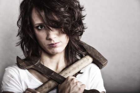Sex equality and feminism. Sexy girl holding hammer and wrench spanner tools. Attractive woman working as repairman.の写真素材