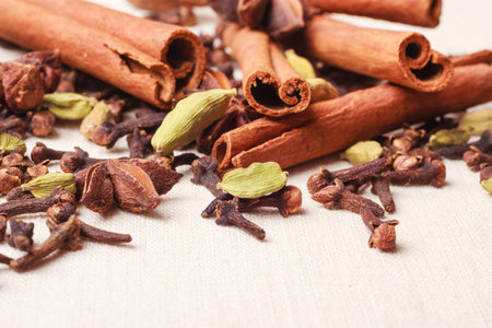 Spices for christmas cakes cinnamon sticks anise stars and cloves on burlap background