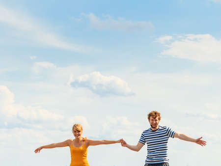 Summer happiness concept. Woman and man young couple in love playing sharing free time having fun outdoor sky backgroundの写真素材