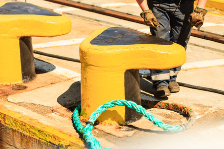 harbor quayside yellow mooring bollard with blue rope in marina outdoor