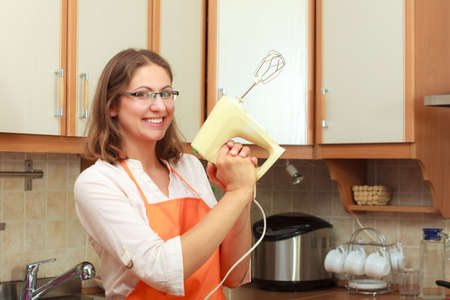 Funny positive housewife chef cook holding mixer. Preparing food meal concept.の写真素材