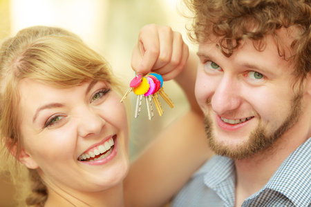 Real estate and family concept. Couple showing their new house keysの写真素材