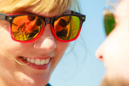 Closeup young loving couple woman man looking to each other outdoor. Boyfriend face reflected in sunglasses his girlfriendの写真素材