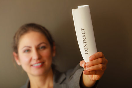 Contracts and agreements concept. Adult beauty woman in jacket holding showing contract. Close up...
