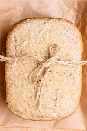 Food. Closeup freshly baked loaf of bread on baking paper top view