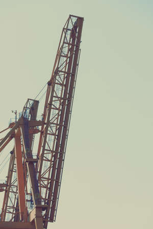 Business and commerce. Cranes at port area, cargo container yard. Industrial scene.の写真素材