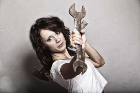 Sex equality and feminism. Sexy girl holding wrench spanner tool. Attractive woman working as repairman or mechanic.の写真素材