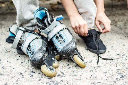 Closeup of woman girl putting on roller skates outdoor.