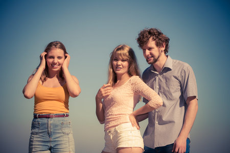 Friendship happiness summer holidays concept. Group of friends boy two girls having fun outdoor...