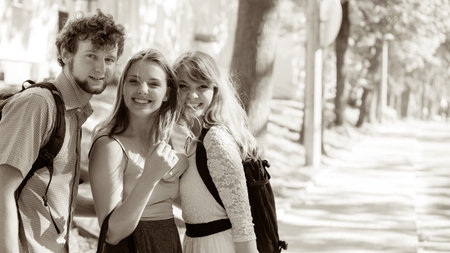 Three happy smiling young people friends outdoor. Attractive women and handsome man portrait. Summer...