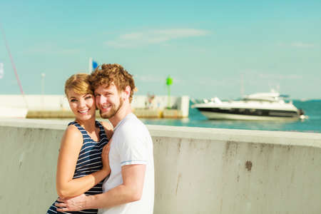 Travel tourism and people concept. Young tourist couple on vacation standing in front of boats sea waterの写真素材
