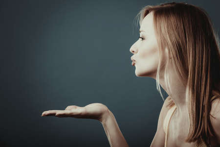Young attractive blonde young woman sending hand kiss.の写真素材