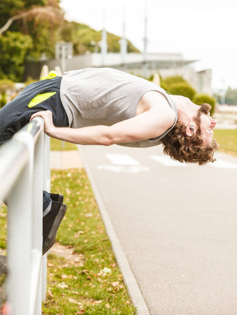 Active young womanman  stretching warming up before exercise. Fit sporty guy in training suit working out. Sport fitness and healthy lifestyle concept.の写真素材