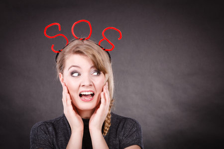 Fear and fright. Young blonde terrified woman needs help. Frightened hopeless female with red sos...
