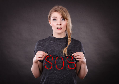 Fear and fright. Young blonde terrified woman needs help. Frightened hopeless female with red sos...