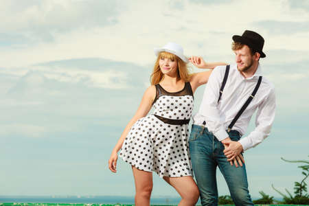 Summer holidays love relationship and dating concept - romantic playful couple retro style flirting outdoor sky backgroundの写真素材