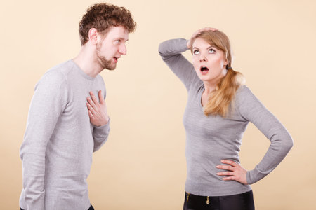 Young blonde couple arguing and yelling on each other.
