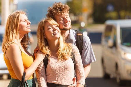 Three happy smiling young people friends outdoor.の写真素材