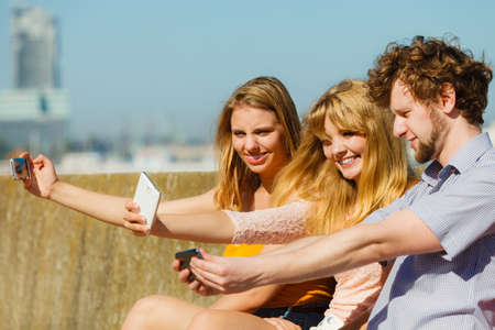 Friends taking selfie self photo picture with smartphone.の写真素材