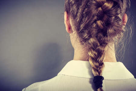 Back view of blonde woman with long elegant braid.の写真素材