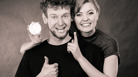 Funny smiling couple playing with moisturizer cream.の写真素材