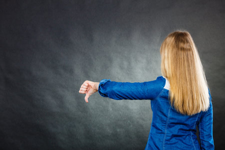 Young depressed unhappy woman covering facial emotions by blonde hair.