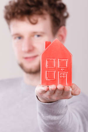 Young man holding house on palm.の写真素材