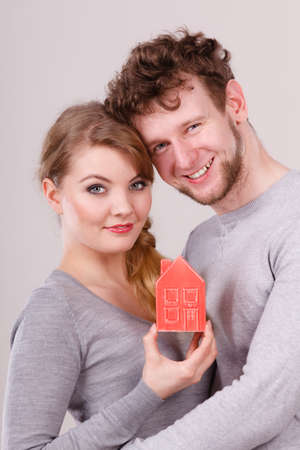 Young lady with man together holding house model.の写真素材