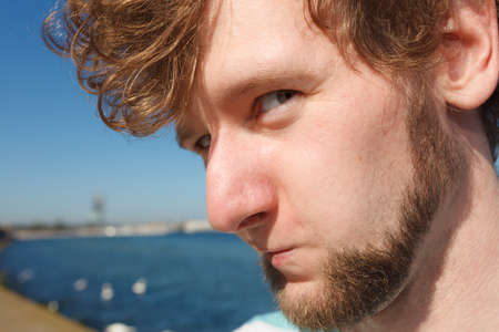 Happy funny young man guy outdoor. Handsome bearded male looking suspiciously.の写真素材