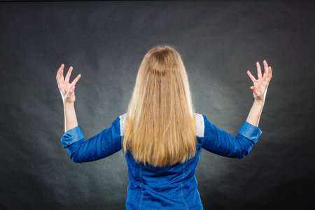Fury and big anger inside of people. Blonde furious woman making hands gestures. Emotional young girl showing her bad expression.の写真素材
