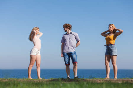 Carefree young friends people relaxing by sea ocean water. Happy man and women hanging out. Summer happiness and freedom.の写真素材