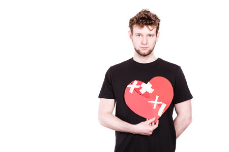 Heart broken concept. Unhappy sad man guy holding glued on love sign symbol. Human feeling repared...
