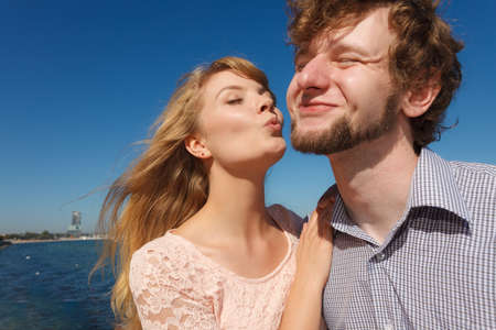 Happiness dating concept. Couple in love blonde woman handsome bearded man enjoy romantic date kissing, outdoor wide angle viewの写真素材