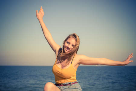Holidays, summertime and freedom concept. Lovely blonde girl relaxing outdoor by seasideの写真素材