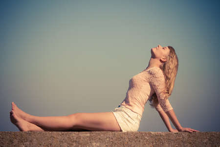 Holidays, summer and freedom concept. Lovely blonde girl resting outdoor  enjoying sunlight filtered photoの写真素材