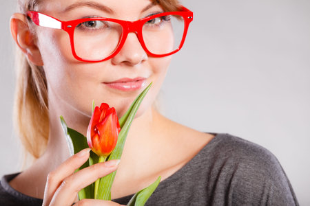 Beauty emotions nature passion glasses concept. Nerdy girl snffing flower. Young blonde casual lady...