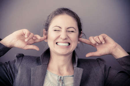 Stress at work. Middle aged stressed angry upset business woman portrait. Face emotion expression. Human on deadline reaction.の写真素材