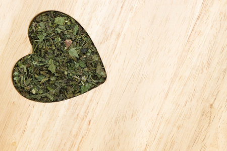 Healthy food, healing herbs, alternative herbal medicine concept. Dried herb nettle leaves in form...