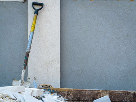 Trash construction building demolition waste hard work concept. Spade in pile of rubble. Manual labor tool sticking out from debris.の写真素材