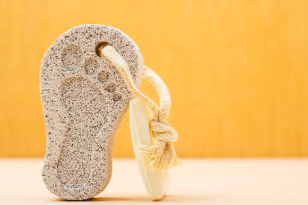 Feet care. Pedicure accessory tool: stone pumice with foot print and bar of soap closeupの写真素材