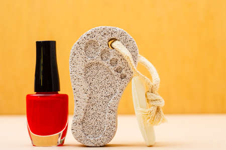 Feet nails care. Pedicure accessories set tools: bar of soap, varnish and stone pumice with foot printの写真素材