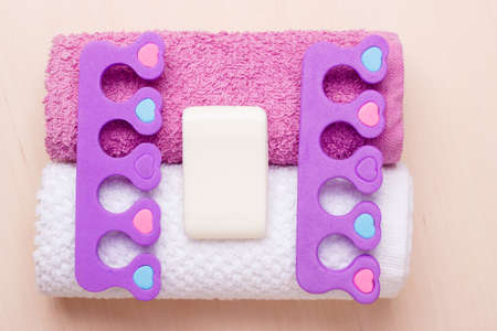 Foot care and cosmetics. Pedicure accessories set tools, two toe separators with bar soap on towelsの写真素材