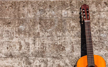 Music sound recreation passion concept. Guitar leaning on wall. Instrument standing outside.の写真素材