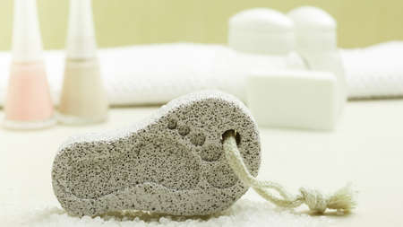 Feet nails care. Pedicure accessories set tools: soap, varnish and stone pumice with foot printの写真素材