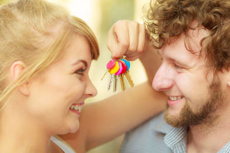 Real estate and family concept. Couple showing their new house keysの写真素材