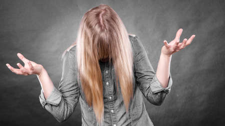 Fury and big anger inside of people. Blonde furious woman making hands gestures. Emotional young girl showing her bad expression.の写真素材