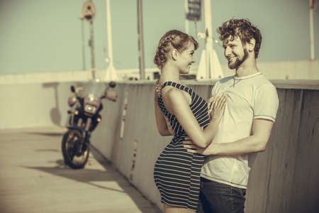 Travel tourism and people concept. Young tourist couple on vacation in sea port motorcycle in the backgroundの写真素材
